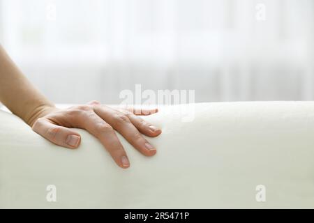 Donna che tocca ortopedico cuscino in schiuma memoria interna, primo piano. Spazio per il testo Foto Stock