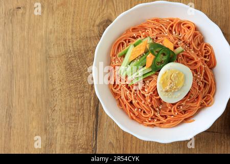 Bibim Guksu Naenmyeon, noodle freddo piccante coreano con cetriolo a fette e Topping uovo bollito, Copia spazio per il testo Foto Stock