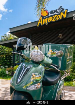 KANCHANABURI-THAILANDIA, 20 ,2020 NOVEMBRE : Green food consegna scooter moto con casco si ferma e attende a casa consegna servizio di fronte Ama Foto Stock