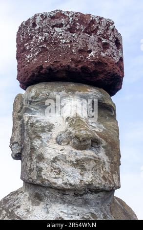 Testa della statua del re di Moai isolato, cappello rosso primo piano verticale Vista laterale del ritratto. Famoso sito archeologico di AHU Tongariki, Isola di Pasqua Rapa Nui, Cile Foto Stock