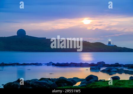 Al crepuscolo il sole si dirige verso l'orizzonte, la sagoma del faro. Fugui Cape Lighthouse è noto per i suoi scatti al tramonto e per l'attrattiva turistica Foto Stock