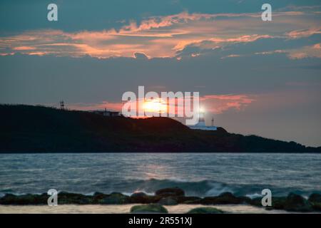 Al crepuscolo il sole si dirige verso l'orizzonte, la sagoma del faro. Fugui Cape Lighthouse è noto per i suoi scatti al tramonto e per l'attrattiva turistica Foto Stock