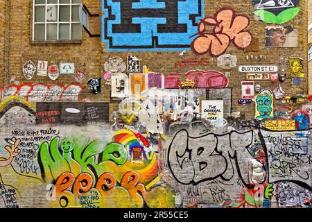 London Brick Lane Tower Hamlets negozi caffè ristoranti muro a Buxton Street con modelli gaffiti e messaggi Foto Stock