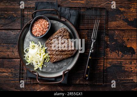 Bistecca di cervo con sale marino e insalata. Sfondo di legno. Vista dall'alto. Foto Stock