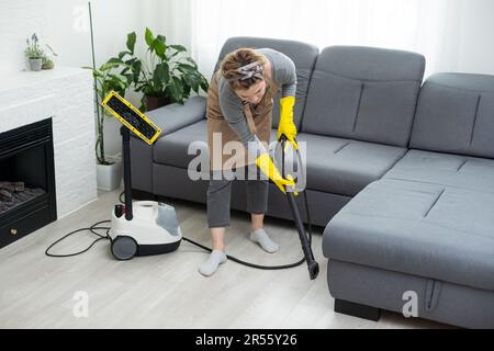 Il dipendente del pulitore a secco rimuove lo sporco dai mobili in un primo piano. Foto Stock