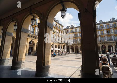 San Sebastian Plaza Constitucion, vista da uno storico colonnato degli appartamenti panoramici all'interno di Plaza de la Constitucion, città vecchia di San Sebastian. Foto Stock