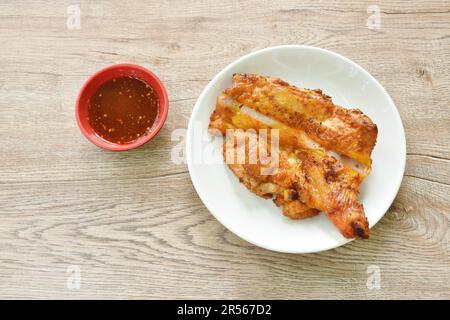 pollo arrosto stretto stabbing bastone di legno su piatto immersione con salsa piccante Foto Stock