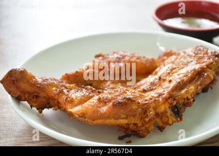 pollo arrosto stretto stabbing bastone di legno su piatto immersione con salsa piccante Foto Stock