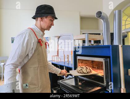 Londra, Regno Unito, 01st giugno 2021. Un rappresentante dell'installazione preleva un pane appena sfornato e profumato dall'installazione austriaca "Brot: Baking the Future" in un'esperienza multisensoriale completamente automatizzata. Catalin Bocirnea, direttore creativo del collettivo Mendel, l'installazione fa parte della London Design Biennale di Somerset House dal 1st al 25th giugno con il tema di quest'anno "il gioco globale: Remapping Collaborations". Dispone di 45 installazioni internazionali. Credit: Imageplotter/Alamy Live News Foto Stock