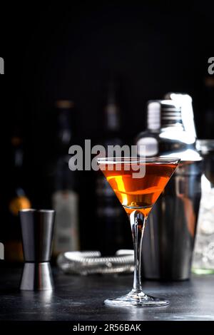 Cocktail alcolico Bobby Burns con whisky scotch, vermouth e liquore in vetro martini, sfondo del banco del bar scuro Foto Stock