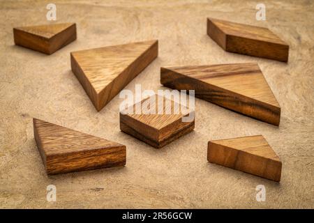 Tangram sette pezzi di legno, un Cinese tradizionale gioco di puzzle, corteccia texture di sfondo della carta Foto Stock