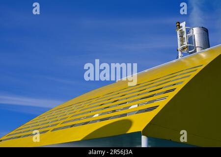 Primo piano degli imbuti di un traghetto per passeggeri che emette fumo contro un cielo blu. Foto Stock
