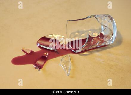 bicchiere rotto con vino rosso versato Foto Stock