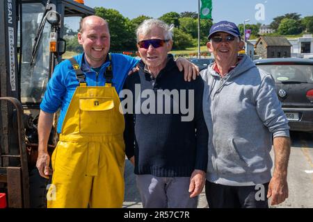 Schull, West Cork, Irlanda. 1st giugno, 2023. Il sole splese oggi nel villaggio costiero di Schull con temperature che raggiungono i 18 gradi Celsius. Tim Griffin, la fabbrica di pesce di Schull e i pescatori locali Michael o'Callaghan e John o'Driscoll sono raffigurati sul molo di Schull. Credit: AG News/Alamy Live News Foto Stock