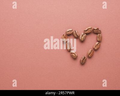 Forma a cuore dei chicchi di caffè su sfondo marrone con spazio per il testo Foto Stock