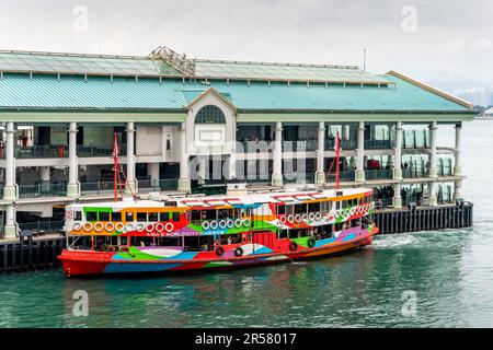 I passeggeri aspettano di salire a bordo Di Un Colourful Star Ferry da un molo sull'Isola di Hong Kong, Hong Kong, Cina. Foto Stock