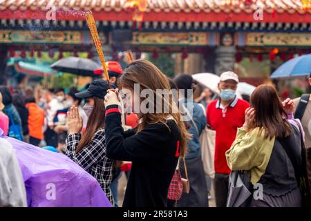 I giovani cinesi adorano il tempio di Wong Tai Sin, Hong Kong, Cina. Foto Stock