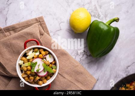 Deliziosa insalata di ceci fatta in casa con feta e ravanello. Cucina fatta in casa. Foto Stock