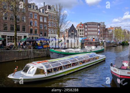 Amsterdam, Olanda del Nord, Paesi Bassi - Aprile 26 2023. Crociera sul canale Prinsengracht in primavera con cielo blu. Foto Stock