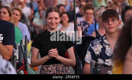 Una giovane donna sorridente tra molti pellegrini durante il Mladifest 2022 – la festa della gioventù – a Medjugorje. Foto Stock