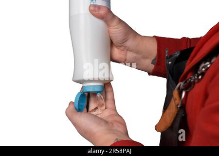 Le mani di un barbiere professionista schiacciano lo shampoo nella sua mano prima di lavare la testa del cliente in un barbiere o parrucchiere su bianco, isolato ba Foto Stock