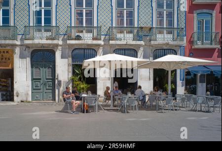 Turisti in un caffè all'aperto nel quartiere Alfama di Lisbona Foto Stock