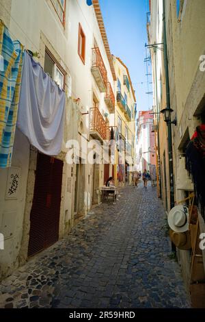 Nel quartiere Alfama di Lisbona le strade sono ombreggiate e strette Foto Stock