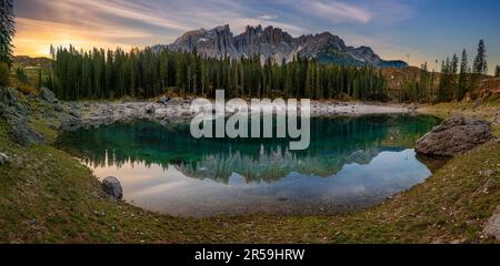 Carezza, Italia - Vista panoramica sul Lago di Carezza con le Dolomiti italiane che si affacciano sul lago. Caldo alba autunnale con colorato Foto Stock