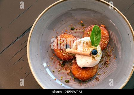 Frittelle di mele con gelato alla vaniglia presso il ristorante svizzero Stadthaus, Unterseen, Svizzera Foto Stock
