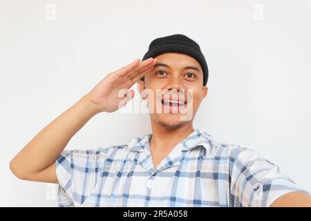 Felice uomo adulto che indossa pigiama e berretto di beanie sorridendo mentre saluta guardando la macchina fotografica. Isolato su sfondo bianco Foto Stock