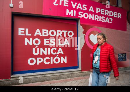 Madrid, Spagna. 02nd giugno, 2023. Una donna passa davanti a un segno che legge 'l'aborto non è l'unica opzione' sulla facciata del 'Pro Life Shelter' di fronte alla clinica Dator. La clinica Dator è una delle cliniche accreditate in Spagna per l'interruzione volontaria della gravidanza. Credit: Marcos del Mazo/Alamy Live News Foto Stock