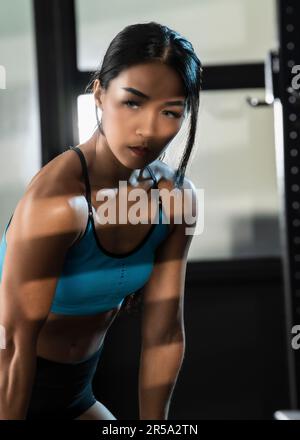 Donna che si esercita in palestra privata a Bangkok Foto Stock