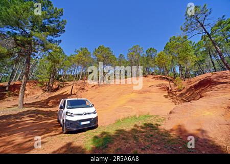 Camper bianco in piedi tra le colline di argilla ocra nel Parco Naturale Regionale Mont-Ventoux, Francia, Provenza, Vaucluse, Mormoiron Foto Stock