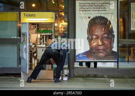 Autista di trasporto in contanti che svuota una macchina per i biglietti sul sistema di tram Manchester Metrolink Foto Stock