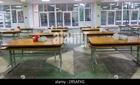 Sedie e tavoli. La sala da pranzo a scuola è in quarantena, isolamento. Foto Stock
