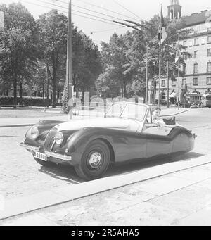 Guida in 1950s. Una giovane donna in una Jaguar XK120 aperta e convertibile. Una sportscar britannica che è stato considerato avere un design futuristico. I numeri 120 indicano la velocità massima della vettura, 120 mph/193 km/h. La vettura era a due posti con una chasse in alluminio. E 'stato realizzato in un totale di 12078 auto. Svezia 1953. rif BL108-8 Foto Stock