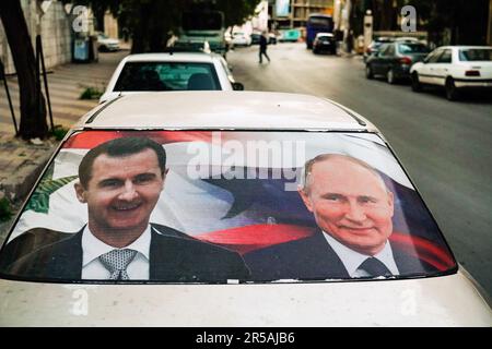 Grandi manifesti con ritratti del presidente siriano Bashar al-Assad e del presidente russo Vladimir Putin su un'auto a Damasco, Siria, 31.March 2023 --- Großplakate mit dem Konterfei des Präsidenten Baschar al-Assad und dem russischen Präsidenten Wladimir Putin an einem Auto a Damaskus, Syrien, 31.March 2023 Foto Stock