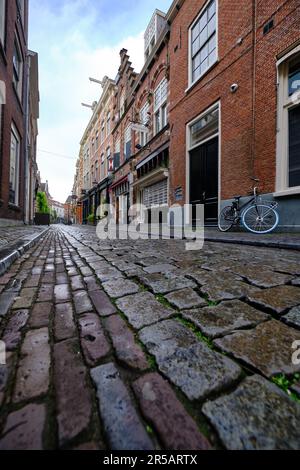 Haarlem, Olanda, 24 maggio 2022: Vista ad angolo basso. Un tranquillo vicolo acciottolato e case tradizionali. Primavera ad Haarlem, Paesi Bassi. Foto Stock