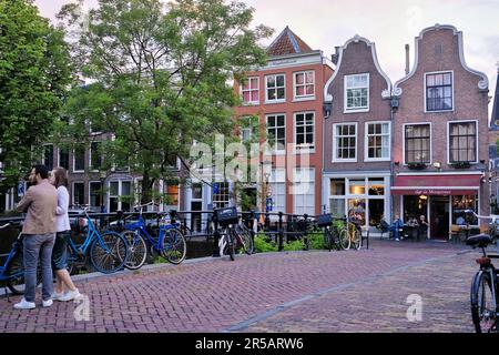 Utrecht, Paesi Bassi - Giugno 07 2022: Una coppia su un ponte sul canale Oudegracht in estate Foto Stock