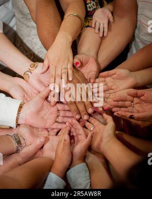 Gruppo di persone che mettono le mani insieme in un cerchio. Festa di famiglia. Foto Stock
