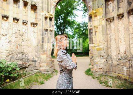 ragazza meditando nelle rovine di una vecchia chiesa Foto Stock