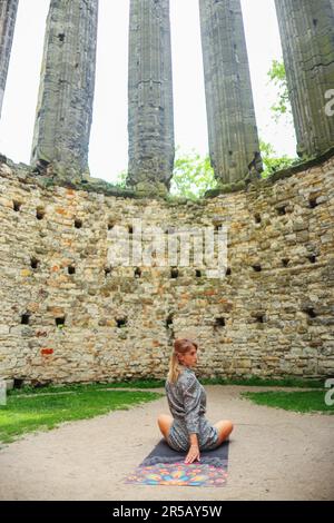 ragazza meditando nelle rovine di una vecchia chiesa Foto Stock