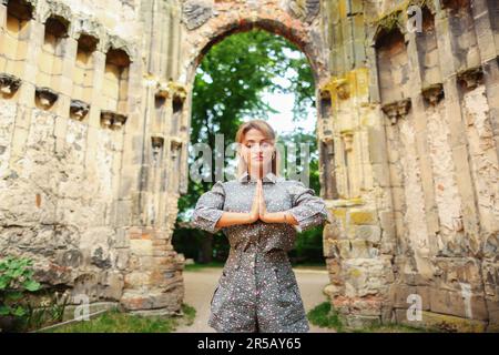 ragazza meditando nelle rovine della vecchia chiesa Foto Stock