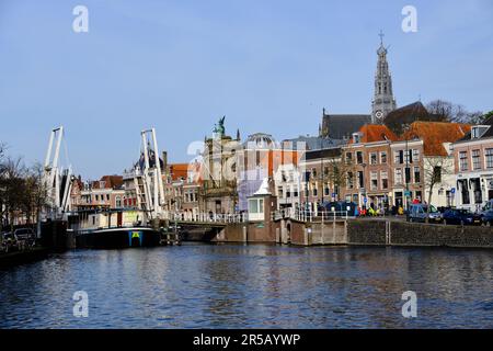Haarlem, Paesi Bassi - 12 aprile 2022: Ponte levatoio di Gravestenen sul fiume Spaarne con case sul canale a timpano. Foto Stock