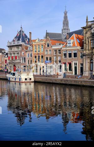 Haarlem, Paesi Bassi - Aprile 12. 2022: Vista panoramica delle tradizionali case olandesi che costeggiano il fiume Sparne in primavera. Barca da diporto ormeggiata nel w Foto Stock