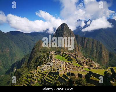 Una vista aerea ravvicinata dell'antico sito Inca di Machu Picchu in Perù, circondato da un lussureggiante terreno montuoso Foto Stock