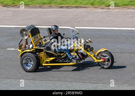 Moto trike Rewaco Yellow a due posti a tre ruote; viaggia a velocità sostenuta sull'autostrada M6 a Greater Manchester, Regno Unito Foto Stock