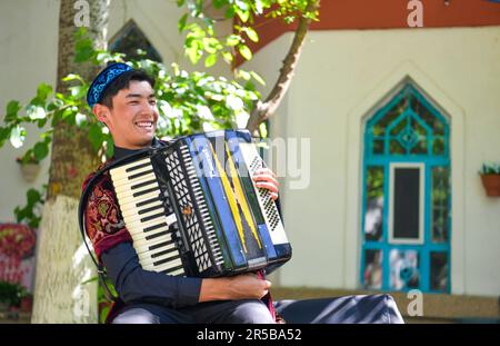 (230602) -- URUMQI, 2 giugno 2023 (Xinhua) -- Un musicista si prepara a suonare la fisarmonica su Liuxing Street nella città di Yining, nella prefettura autonoma di Ili Kazak, nella regione autonoma dello Xinjiang Uygur, nel nord-ovest della Cina, il 17 maggio 2023. Secondo un calcolo completo attraverso una piattaforma di big data per le statistiche del turismo e un sondaggio campione, da gennaio ad aprile 2023, Xinjiang ha ricevuto oltre 51,19 milioni di turisti, un aumento annuale del 29,56%. Nel frattempo, il fatturato del turismo ha raggiunto i 42,64 miliardi di yuan (circa 6,03 miliardi di dollari USA), con un aumento del 60,59% su base annua. (Xinhua/Wang Fei) Foto Stock