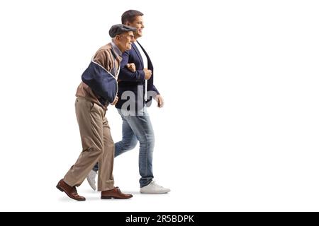 Giovane uomo che cammina con un uomo anziano con un braccio ferito in una fionda isolata su sfondo bianco Foto Stock