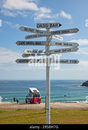 Durness, NW Scottish Highlands, Scozia, Regno Unito. Il sole con una temperatura di 16 gradi centigradi al campeggio Sango Sands Durness si affaccia sulla splendida spiaggia sabbiosa con acque turchesi nella contea di Sutherland. Il villaggio più a nord-ovest della terraferma britannica e da non perdere per chi viaggia lungo il percorso turistico della costa settentrionale 500. Nella foto: Postazioni delle dita presso il campeggio Durness, che indica luoghi in tutto il mondo con un camper VW rosso e bianco sullo sfondo. Foto Stock